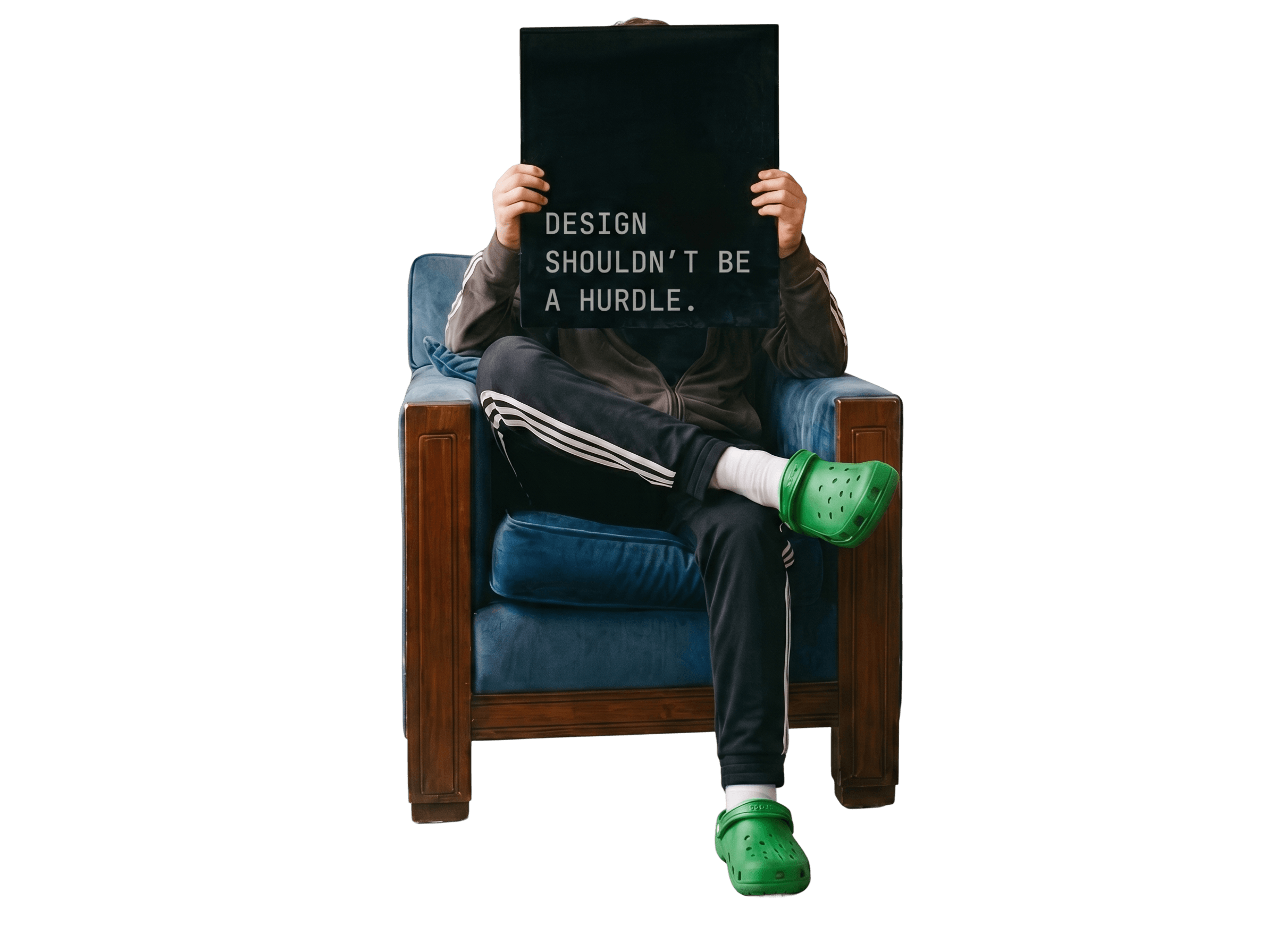 Designer sitting in a blue armchair holding a dark sign reading DESIGN SHOULDN'T BE A HURDLE
